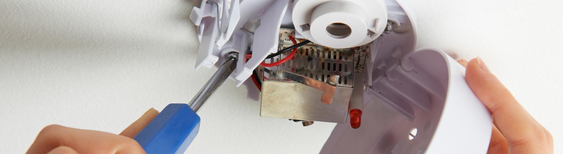 Technician servicing a commercial smoke detector